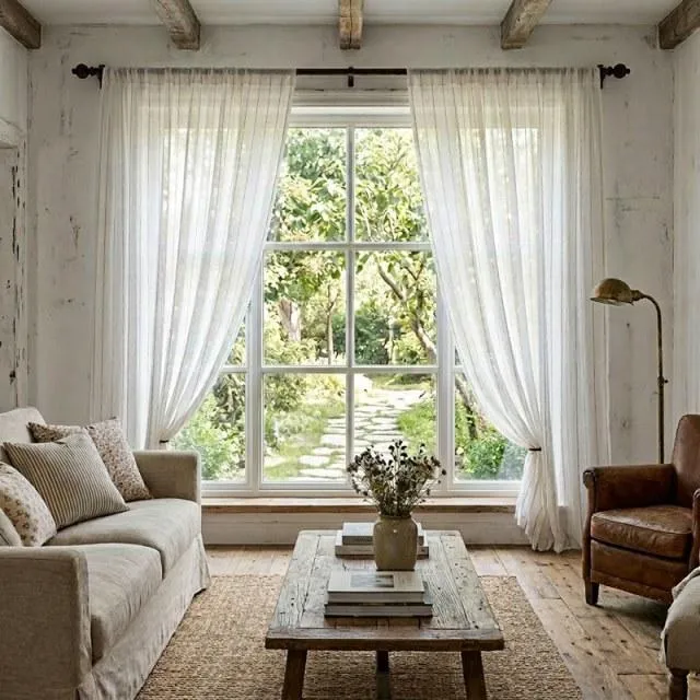 Soft cream curtains framing a cottage living room window