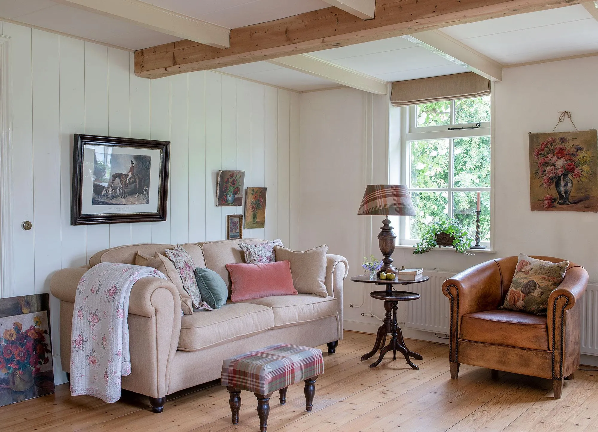 Vintage wooden armchair beside a modern cream sofa in a cottage living room