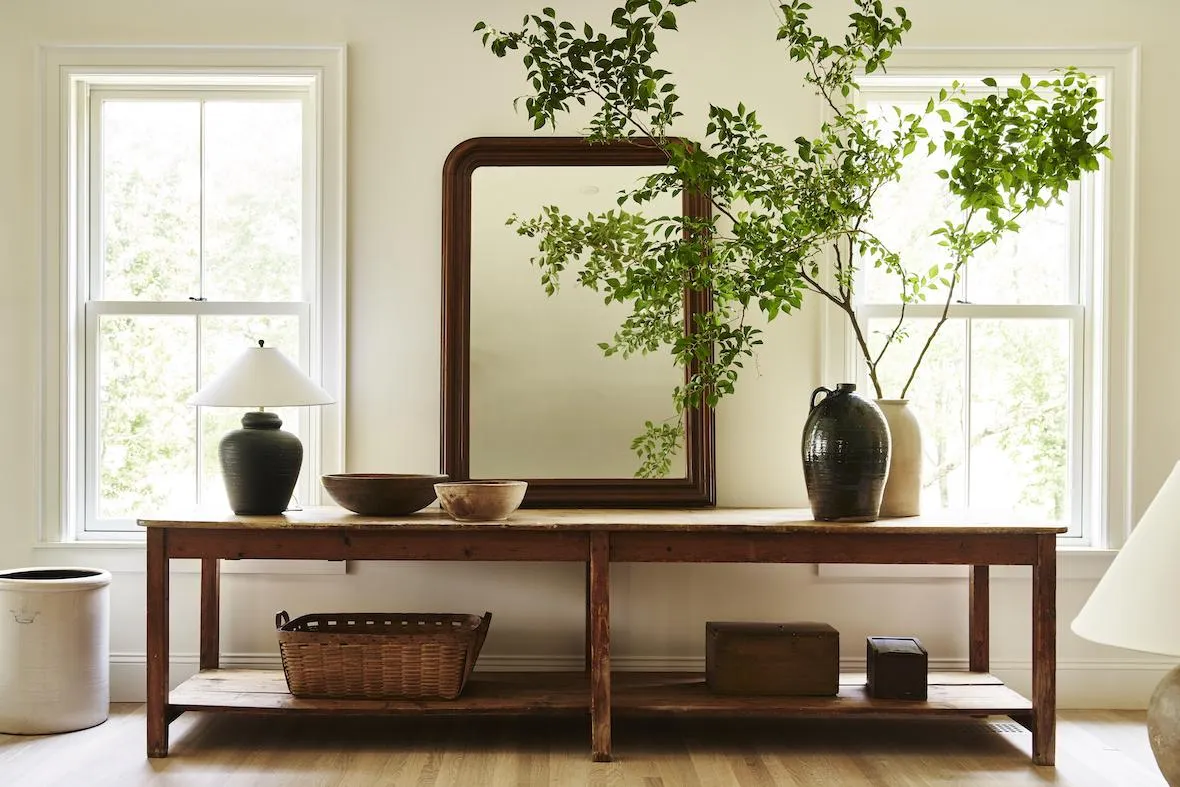 Vintage framed mirror above a simple console table in a cottage entryway